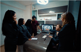 Cinco doutores reunidos, analisando minuciosamente um raio X panorâmico e discutindo estratégias de tratamento para o paciente.